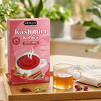 Hemani Kashmiri Kehwa instant herbal tea box with brewed tea, spices, and rose buds on wooden tray