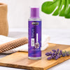 Lavender hair tonic in purple bottle with fresh lavender sprigs on wooden board, natural hair care